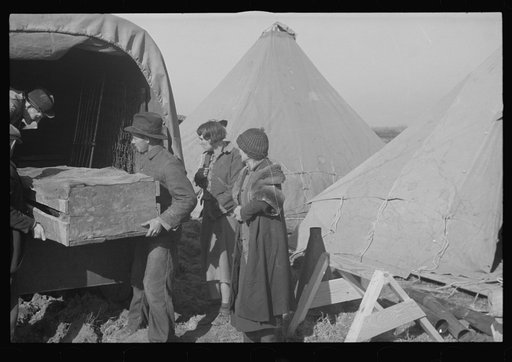 Unloading household goods of a family of white flood refugees in camp at Forrest City, Arkansas