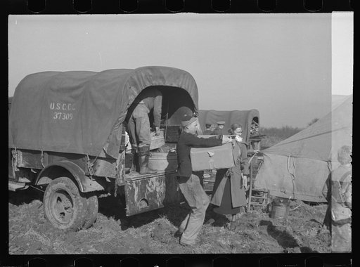 Unloading the household goods of a family who is being moved into the camp for white flood refugees at Forrest City, Arkansas