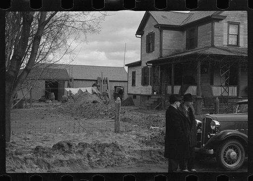 Untitled photo, possibly related to: Flood debris in yard of resettlement client. The wheelbarrow floated to its precarious position on the roof. Hatfield, Massachusetts