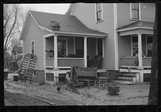 Flood debris in yard of resettlement client. The wheelbarrow floated to its precarious position on the roof. Hatfield, Massachusetts