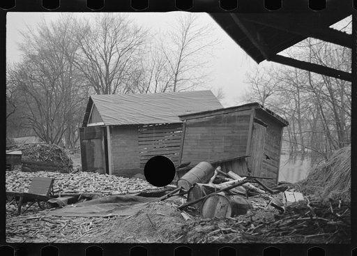 Untitled photo, possibly related to: Flood debris in yard of resettlement client. The wheelbarrow floated to its precarious position on the roof. Hatfield, Massachusetts