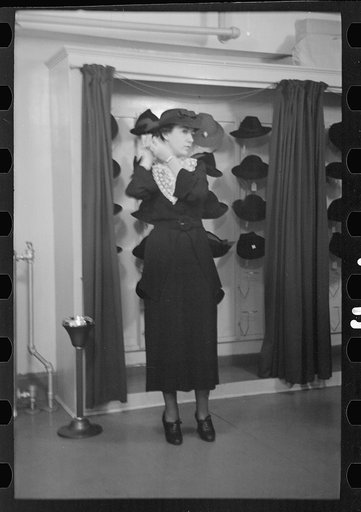 Untitled photo, possibly related to: Model trying on hat for a buyer, New York City showroom, Jersey Homesteads cooperative
