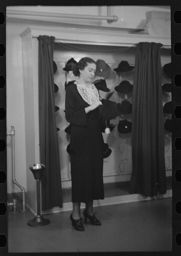 Untitled photo, possibly related to: Model trying on hat for a buyer, New York City showroom, Jersey Homesteads cooperative