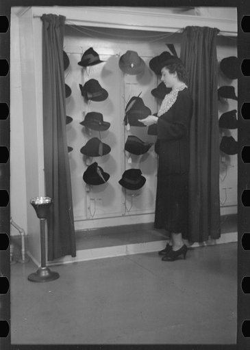 Untitled photo, possibly related to: Model trying on hat for a buyer, New York City showroom, Jersey Homesteads cooperative