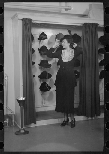 Untitled photo, possibly related to: Model trying on hat for a buyer, New York City showroom, Jersey Homesteads cooperative