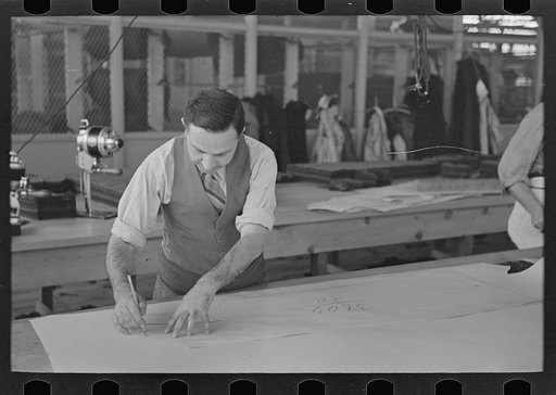 Louis Gushen, chief cutter in the cooperative garment factory at Jersey Homesteads, is cutting the pattern for a woman's coat. Hightstown, New Jersey