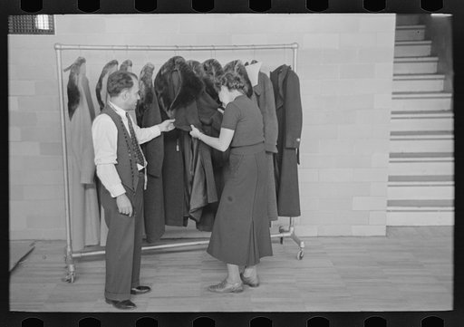 Sam Schultz shows a model coat to a perspective customer at the cooperative garment factory, Jersey Homesteads