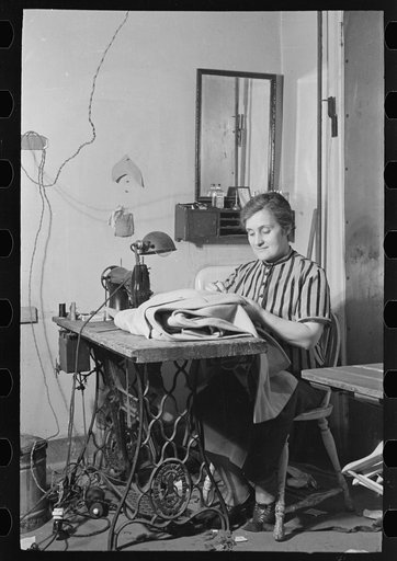 Woman at sewing machine in New York tailor shop on University Place near 11th Street