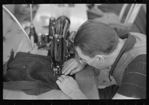 Closeup of man working sewing machine in garment factory, Jersey Homesteads, Hightstown, New Jersey