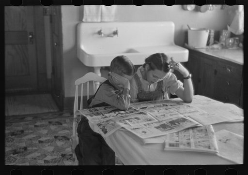 Children reading Sunday papers, Rustan brothers' farm near Dickens, Iowa. Note convenience of running water in background. This farm was formerly owner operated but they are now tenants of Metropolitan Life
