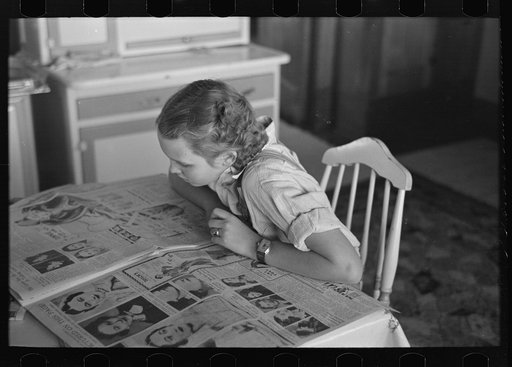 Untitled photo, possibly related to: Rustan's daughter reading a Sunday paper. Rustan brothers' farm near Dickens, Iowa