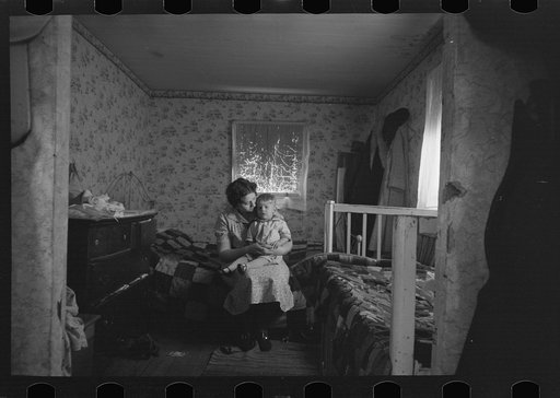 Untitled photo, possibly related to: Mother and child in crowded bedroom of home of L.H. Nissen, hired man. He is married, has seven children, one grandchild, all living together in three rooms