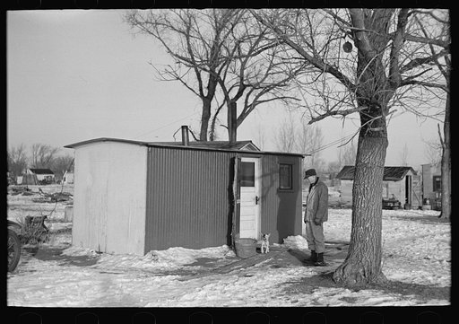 Marcus Miller in front of the shack he built for himself, Spencer, Iowa