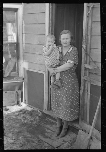 Untitled photo, possibly related to: Mrs. Paul Rauhauser and two of her seven children in their home at Ruthven, Iowa