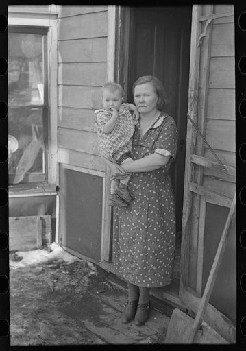 Untitled photo, possibly related to: Mrs. Paul Rauhauser and two of her seven children in their home at Ruthven, Iowa
