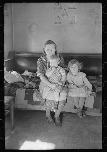 Mrs. Paul Rauhauser and two of her seven children in their home at Ruthven, Iowa