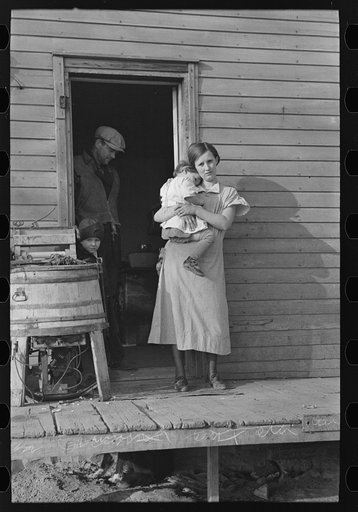 Mrs. Glen Cook and baby with Mr. Cook in background, Little Sioux township, Woodbury County, Iowa