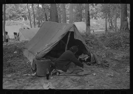 Untitled photo, possibly related to: Woman in front of tent, blueberry camp, near Little Fork, Minnesota