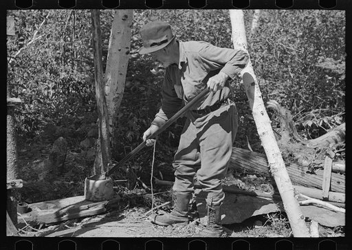 William Besson removing the iron pipe drill from casing near Winton, Minnesota