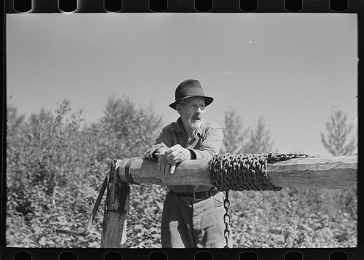 William Besson resting on the windlass of his mine shaft, near Winton, Minnesota