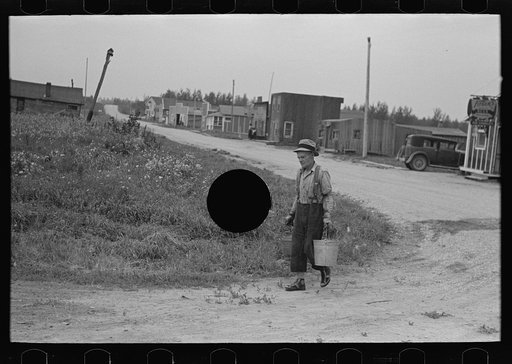 Untitled photo, possibly related to: Herman Gerling dipping water from a spring to fill the barrels on his truck. North Dakota