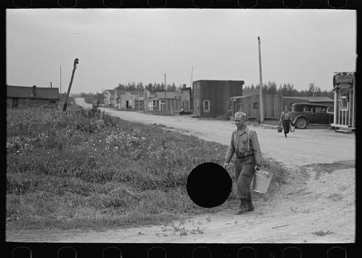 Untitled photo, possibly related to: Herman Gerling dipping water from a spring to fill the barrels on his truck. North Dakota
