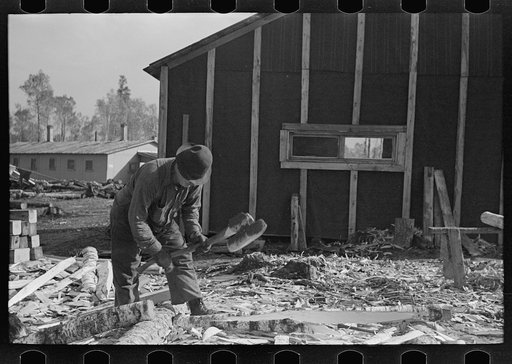 Untitled photo, possibly related to: Lumberjack with stake which he has been shaping with broadaxe, at camp near Effie, Minnesta