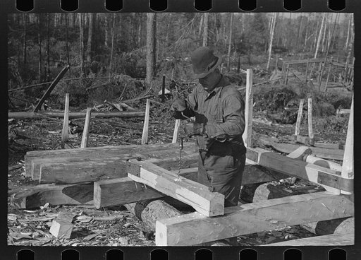 Untitled photo, possibly related to: Drilling hole in construction of sleds for hauling timber at camp near Effie, Minnesota