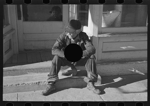 Untitled photo, possibly related to: Arnegard, McKenzie County, North Dakota. Old man sitting on a store step