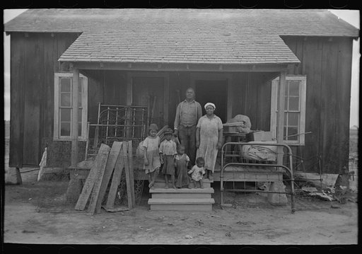 Southeast Missouri Farms. Family of FSA (Farm Security Administration) client on front porch of their old home, just before moving to new home