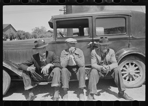 Farmers sitting on running board of car at liquid feed loading station, Owensboro, Kentucky