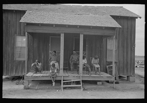 Family of FSA (Farm Security Administration) client farmer sharecropper on porch of old home, Southeast Missouri Farms