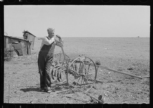 FSA (Farm Security Administration) client leaning on handle of machine for cultivating bought with loans made available to him by FSA, Southeast Missouri Farms