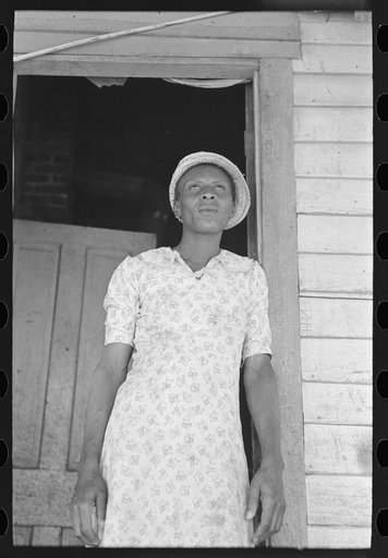 Untitled photo, possibly related to: Part of sharecropper family on porch of cabin. Note the absence of storage space