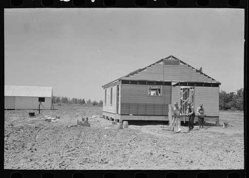Untitled photo, possibly related to: Southeast Missouri Farms Project. Fieldhouse erection. Removing gin pole after gable ends are in place and braced