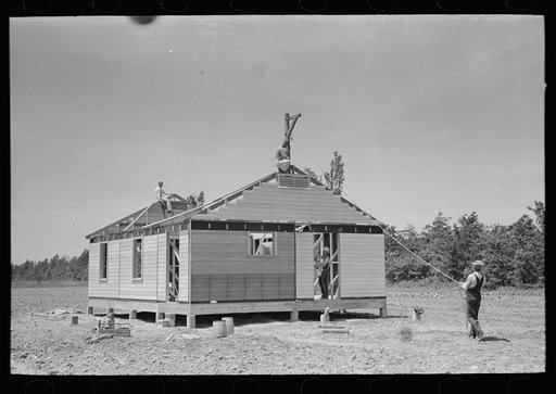 Untitled photo, possibly related to: Southeast Missouri Farms Project. Fieldhouse erection. Removing gin pole after gable ends are in place and braced
