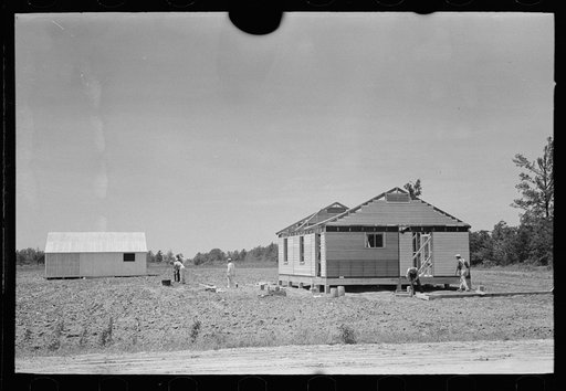 Untitled photo, possibly related to: Southeast Missouri Farms Project. Fieldhouse erection. Removing gin pole after gable ends are in place and braced