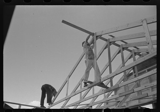 Southeast Missouri Farms Project. House erection. Trusses are raised in place and spaced at the top, ends are automatically spaced by placing joist directly over studs