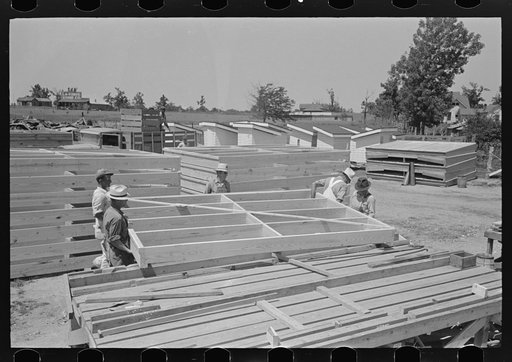 Porch plant. Finished floor framing panel being lifted from framing table to the stack. Southeast Missouri Farms Project