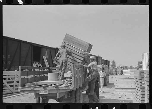 Untitled photo, possibly related to: Southeast Missouri Farms Project. Transportation; privies being loaded onto truck. Wood cribbing is for privy well