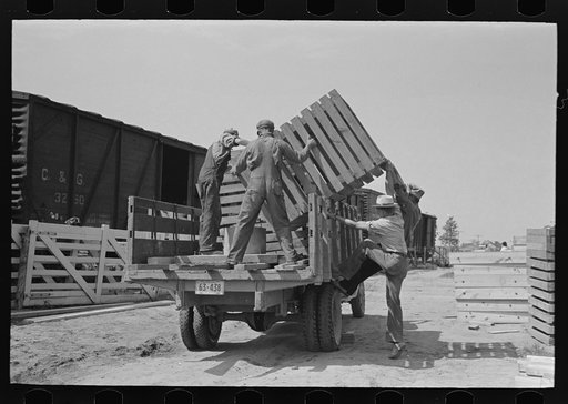 Southeast Missouri Farms Project. Transportation; privies being loaded onto truck. Wood cribbing is for privy well