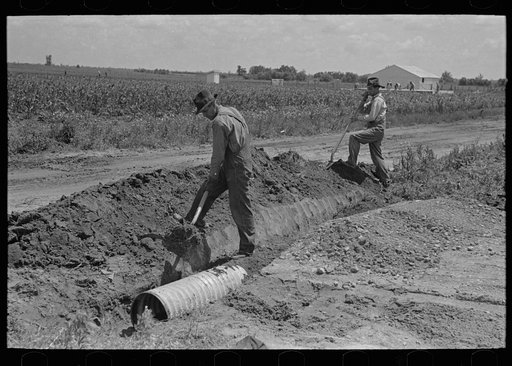 Untitled photo, possibly related to: Southeast Missouri Farms Project. Fitting culvert between main road and farm drive
