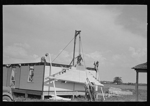 Southeast Missouri Farms Project. House erection. Raising gable ends into place by means of gin pole and skids