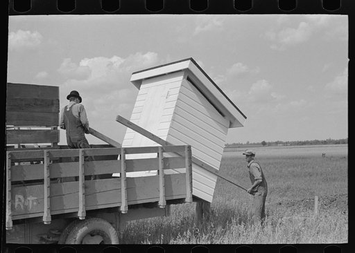 Southeast Missouri Farms Project. Unloading privy house at job site
