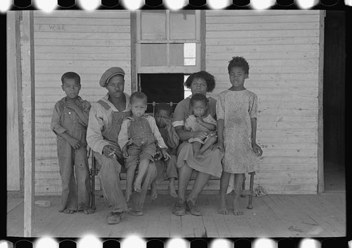 Family of FSA (Farm Security Administration) client, former sharecropper, on porch of old shack home. New Madrid County, Missouri