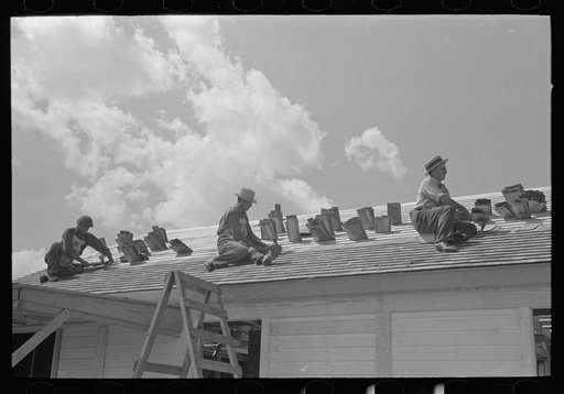 Southeast Missouri Farms Project. House erection. Shingling crew at work on roof. Shingles are tucked in roof lath to keep them from blowing away