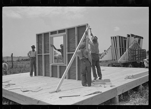 House erection. First panel off the truck is made into an easel for the other panels. The panels will be unloaded in sequence for erection to avoid handling. Southeast Missouri Farms Project