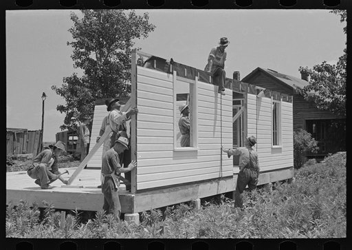 Southeast Missouri Farms Project. House erection. Erecting panels around perimeter of house. Note that regular erection crew is only five men. There was a double crew on this house