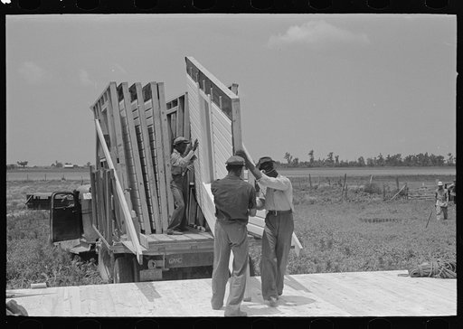 House erection. Unloading panels onto the platform. Southeast Missouri Farms Project