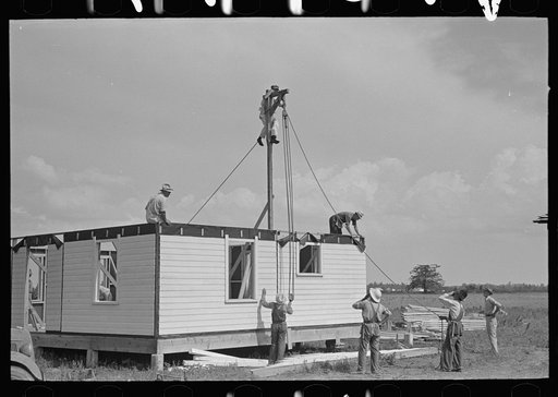 Southeast Missouri Farms Project. House erection. Fastening gin pole preparatory to raising the gable end in place